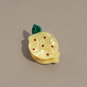 Vue détaillée d'une pince à cheveux citron en acétate avec finition jaune nacrée
