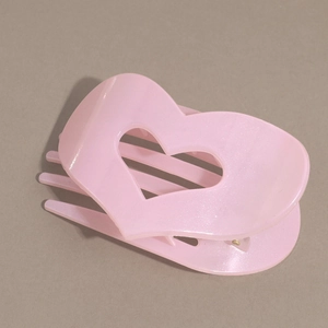 Dettaglio della molletta a cuore rosa con glitter perlati e design ergonomico curvo