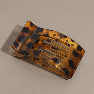 Detailed macro view of the tortoise shell resin hair claw with strong metal spring