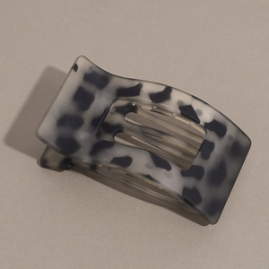 Close-up of matte leopard print hair claw clip showing curved teeth and flat design