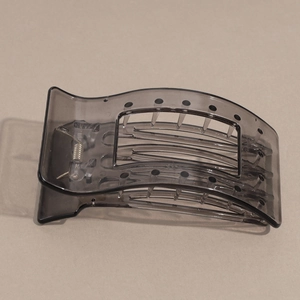 Detail of grey leopard pattern hair claw clip with transparent finish and metal spring