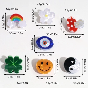Vue détaillée de mini pinces à cheveux en acrylique avec motifs arc-en-ciel et trèfle