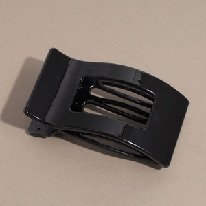 Macro shot of glossy black rectangular hair claw clip with geometric cutout design