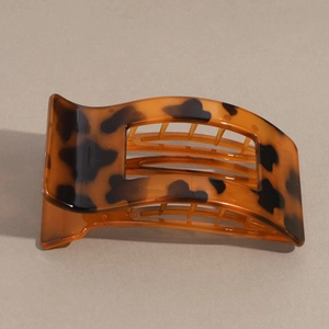 Close-up of vintage tortoiseshell hair claw clip with glossy leopard pattern and hollow design