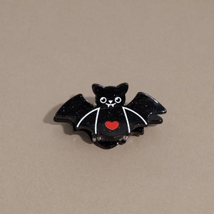 Close-up of black bat hair claw clip with red heart detail for Halloween styling