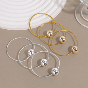 Set of 6 high-elastic hair ties with minimalist gold and silver metallic balls on beige surface