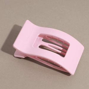 Detail of matte pink rectangular hair claw clip with internal multi-tooth structure