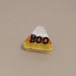 Detail of candy corn colored hair claw clip with BOO text and glittery finish