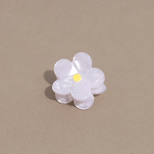Détail d'une mini pince à cheveux en forme de fleur en acétate blanc perlé
