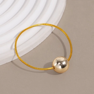 Detail view of a gold elastic hair tie with a large polished metallic bead accessory