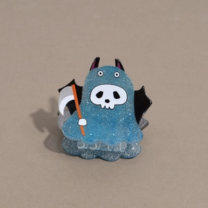Detailed close-up of a blue glittery ghost hair claw with bat wings and a scythe for Halloween