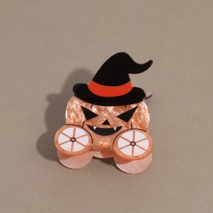 Close-up of glittery orange pumpkin hair claw clip with a black wizard hat detail