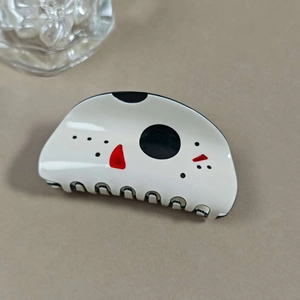 Détail d'une pince à cheveux d'Halloween blanche avec motifs abstraits noirs et rouges