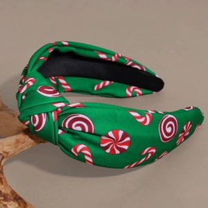 Christmas green fabric knotted headband with candy prints and rhinestones on wood stand