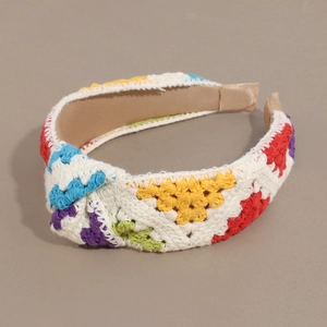 Detail of colorful crochet knit headband with rainbow pattern and twisted knot design