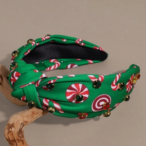 Close-up of a festive Christmas knot headband featuring colorful rhinestones and candy prints