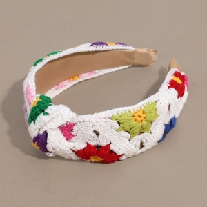 Detail of floral crochet headband with colorful knitted flowers and wide knotted design