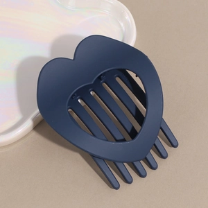 Close-up of a matte dark blue heart-shaped hair claw clip with a hollow design