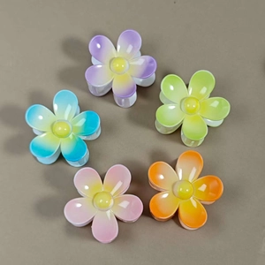 Detailed macro view of five gradient color floral hair claws in resin material