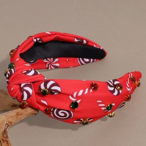 Detail of red Christmas knot headband with candy prints and multicolored rhinestones