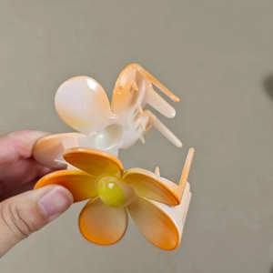 Fashionable floral hair claw clip with orange gradient design for elegant hairstyling