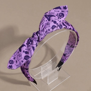Dettaglio cerchietto viola per Halloween con fiocco e stampe di fantasmi e zucche