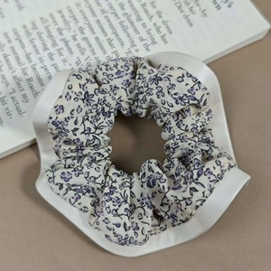 Détail d'un chouchou floral sur un plateau en céramique avec un éclairage doux