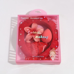 Pink gift box containing red braided headband, wristbands, hair clip and makeup sponge