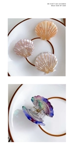 Detail of shell-shaped hair claw clip with pearlescent finish and golden radiating lines