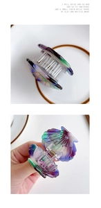 Detail of shell-shaped acetate hair claw with iridescent purple and green gradient