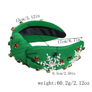 Detail of green knot headband with red rhinestones and white bead snowflake patterns