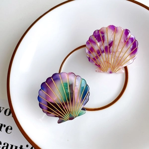 Shell-shaped hair claw clips set in purple marble and gradient colors with gold lines