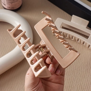Vue détaillée de la grande pince à cheveux carrée beige avec dents à double rangée