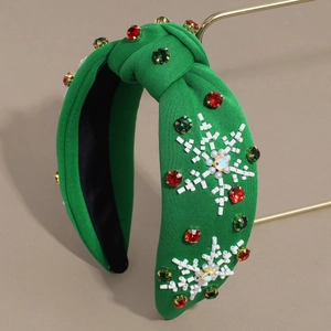 Green knotted headband with sparkling rhinestones and white beaded snowflake patterns