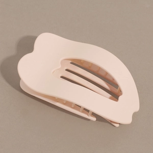 Detail view of pink matte hair claw clip with curved design and heart cutout detail