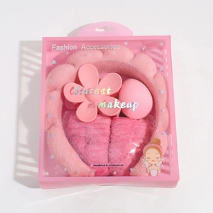 Pink plush headband set including wristbands, makeup sponge, and a flower claw clip in a gift box