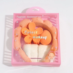 Pink gift box set with orange plush headband, wristbands, flower clip, and beauty blender