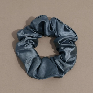 Detailed view of large blue-grey scrunchie with soft ribbed texture and silk satin finish