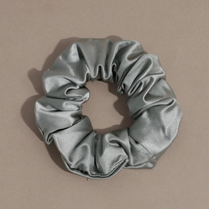 Detailed close-up of grey satin scrunchie showing the soft silk texture and fabric weave