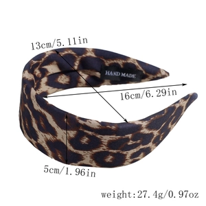 Detail view of leopard print headband showing handmade label and premium fabric texture