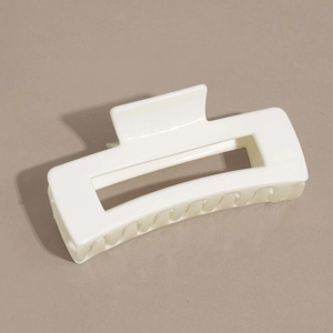 Détail de la pince à cheveux rectangulaire crème avec une finition lisse polie