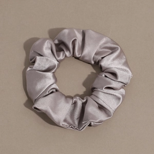 Detailed view of champagne satin silk scrunchie with soft texture and elegant sheen