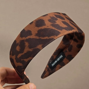 Detail of leopard print wide headband with handmade woven texture and interior fabric label
