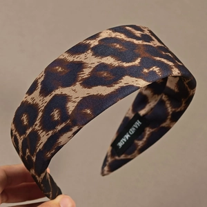 Fashionable leopard print wide headband with handmade tag on a solid fabric finish