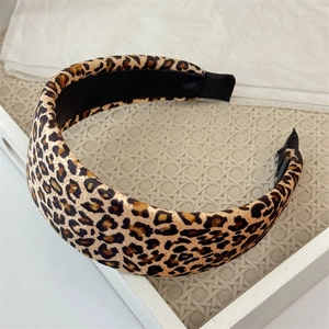 Detailed view of wide leopard print headband with sponge padding on a white tray