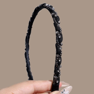 French vintage black twisted headband with silver chain and rhinestones held in hand