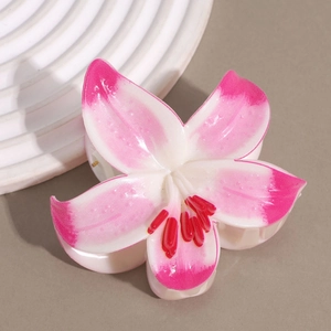 Detail of lily-shaped hair claw clip with pink and white gradient finish and glossy texture