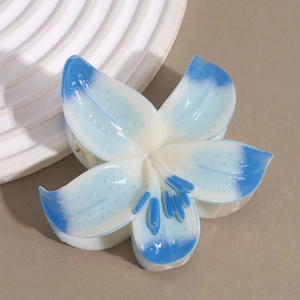Close-up of a blue and white lily flower hair claw clip with detailed resin petals