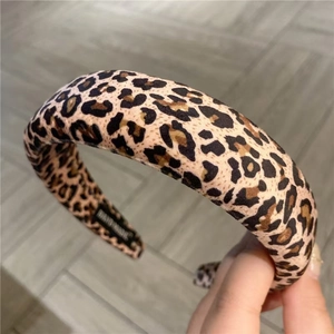 Detailed close-up of leopard print headband with soft fabric texture and handmade label