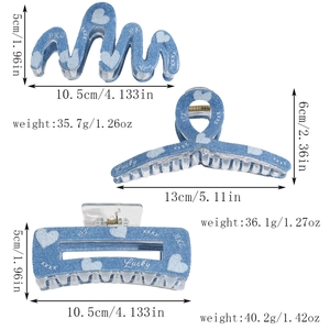 Detail of blue denim textured hair claws with heart prints and size dimensions